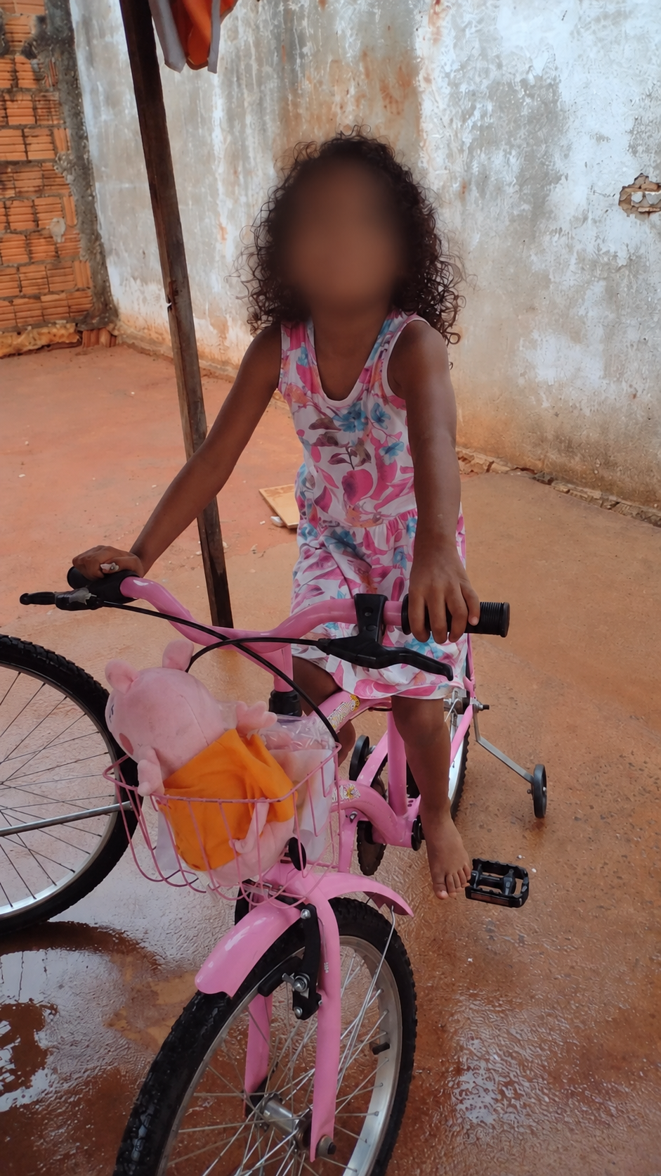 Criança em uma bicicleta rosa
